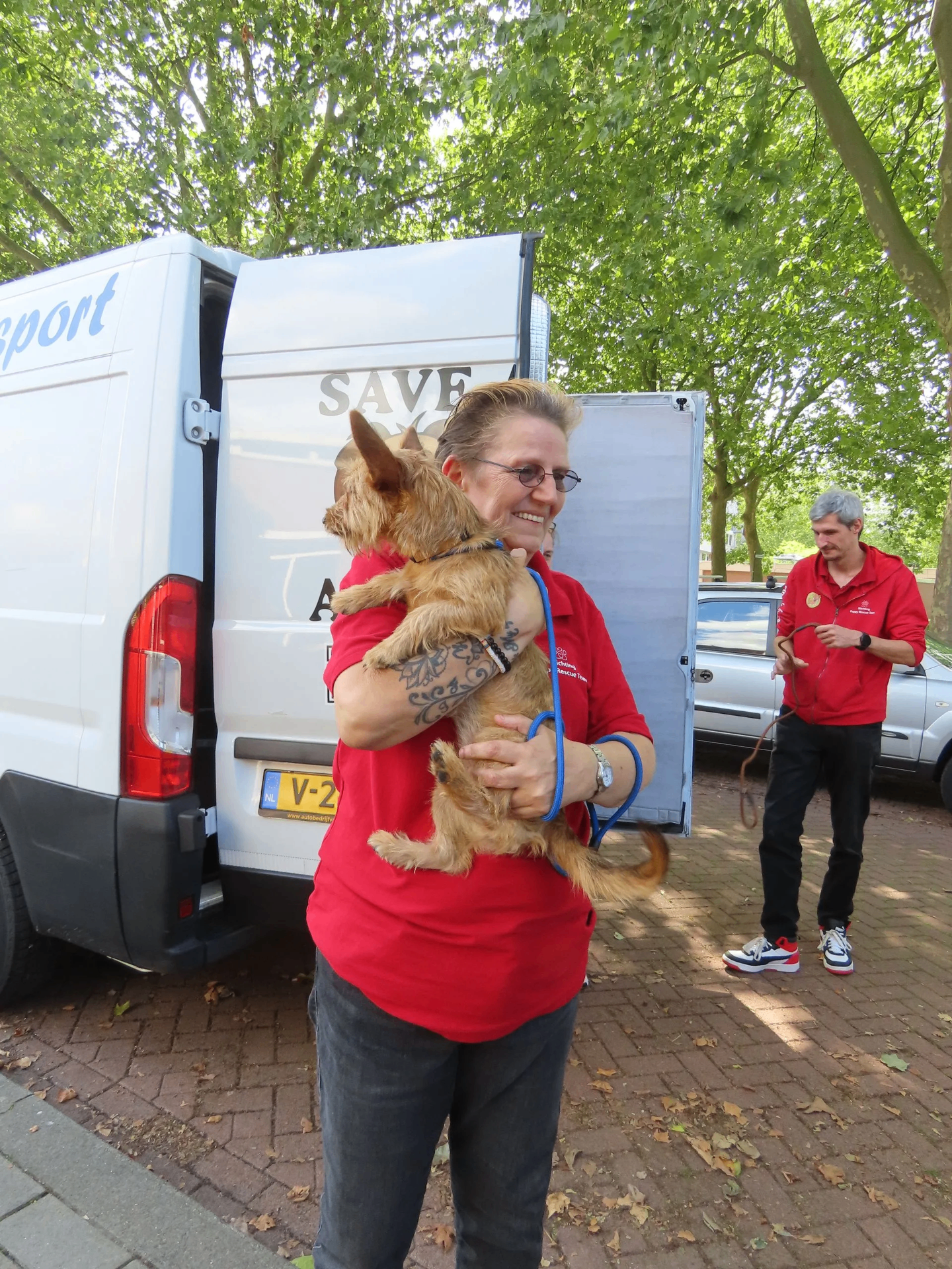 Vrijwilliger van Puppy Rescue Team neemt een hond in ontvangst na transport naar Nederland